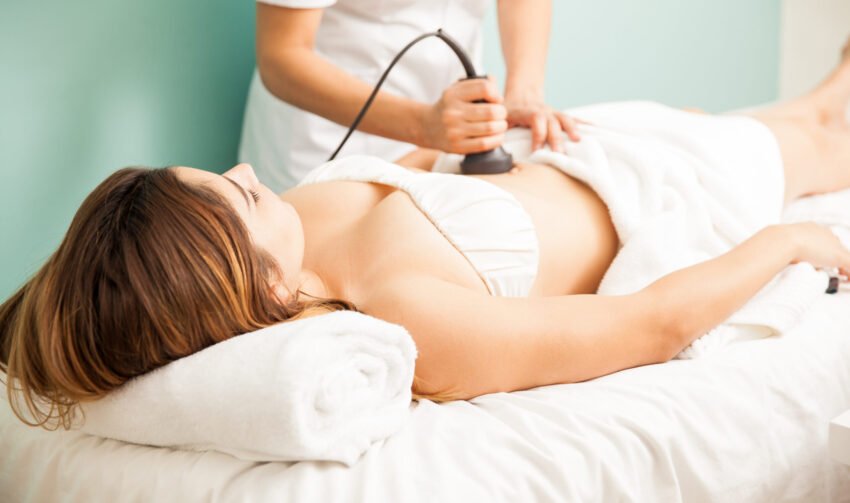 Therapist giving a reductive massage Female therapist giving a reductive and reaffirming treatment to a client and focusing on her belly